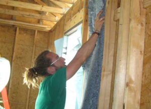 Volunteer installing insulation.