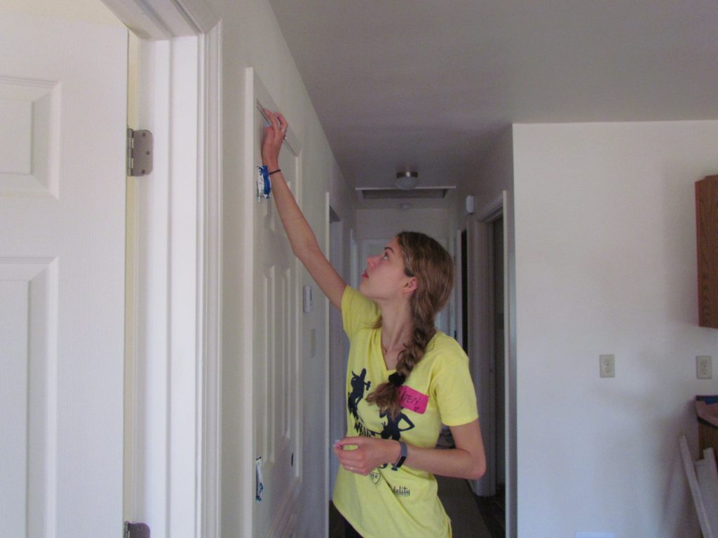 A Women Build 2019 volunteer puts finishing touches on the interior of a Habitat home.
