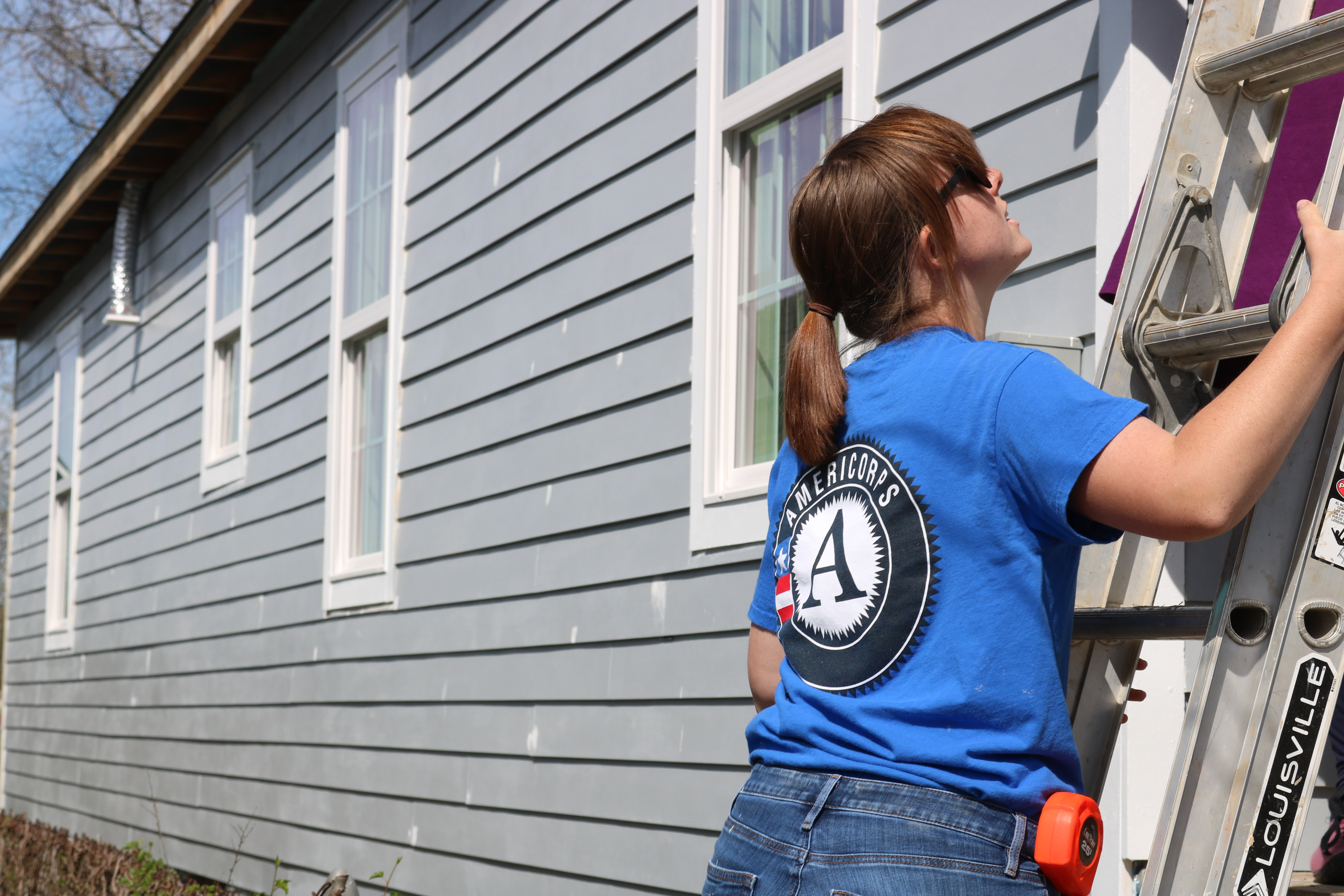 Sara with her AmeriCorps shirt on a Habitat build site.