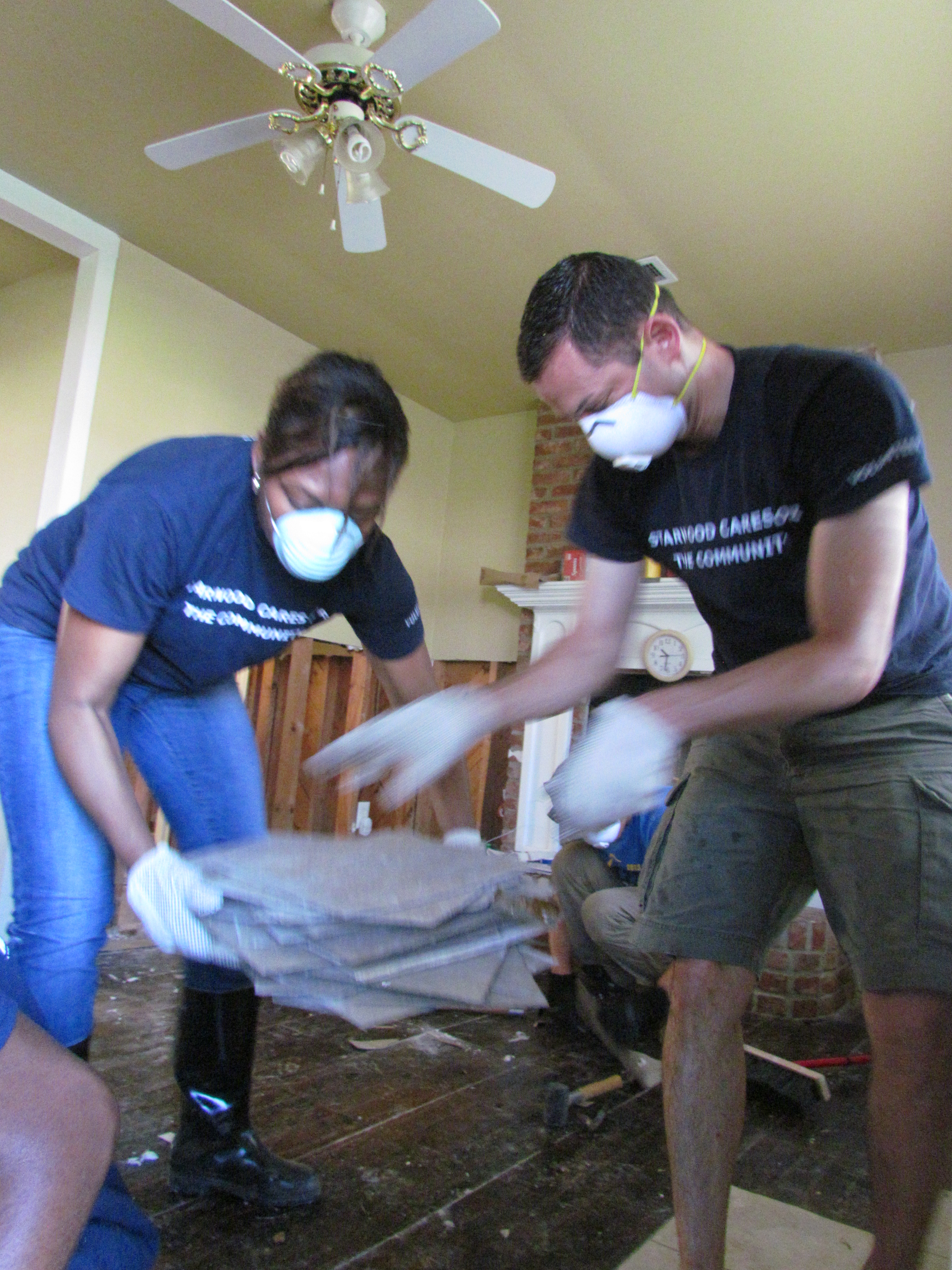 Volunteers removing tiles from a flooded home.