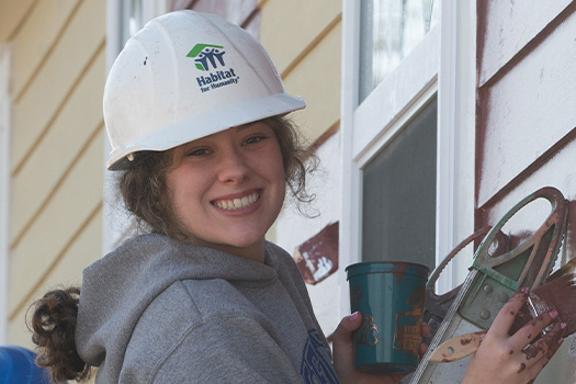Volunteer painting and smiling.